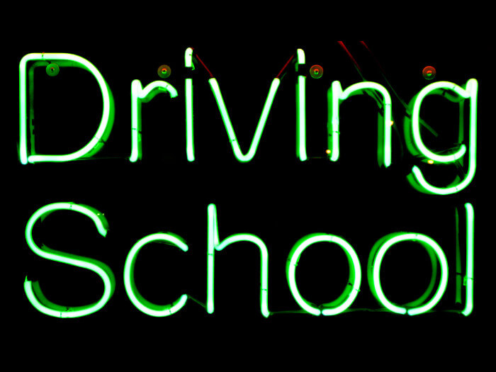Green neon sign advertising driving school