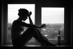 La donna di umore depresso si siede sulla finestra